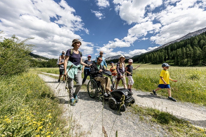 Familie mit Rollstuhlfahrer spaziert im Val Müstair Familie mit Rollstuhlfahrer spaziert im Val Müstair